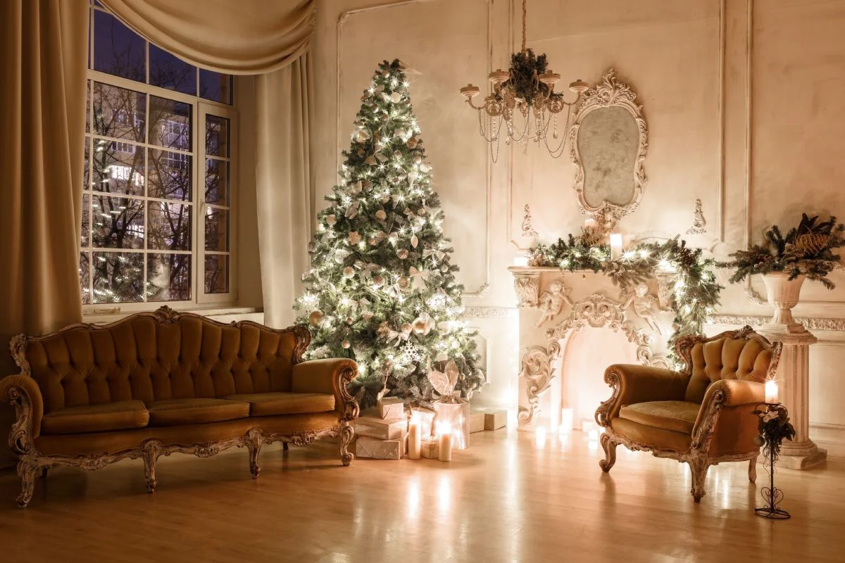 Chesterfield sofa and chair next to a decorated Christmas tree and fireplace in a lounge