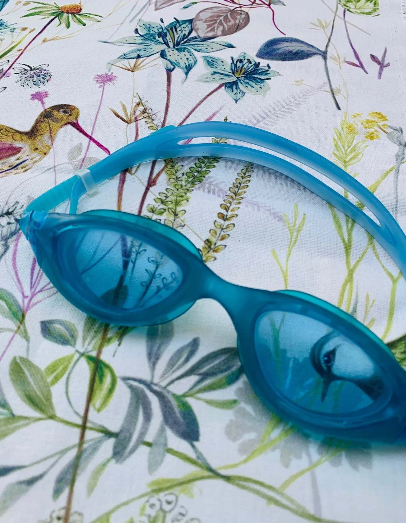 swimming googles on botanical fabric