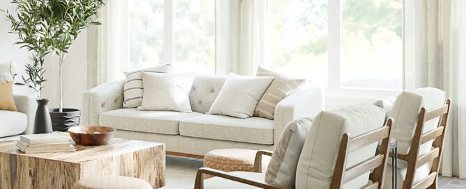 Voile curtains in a sun filled lounge with sofa, two arm chairs, a coffee table and a footstool